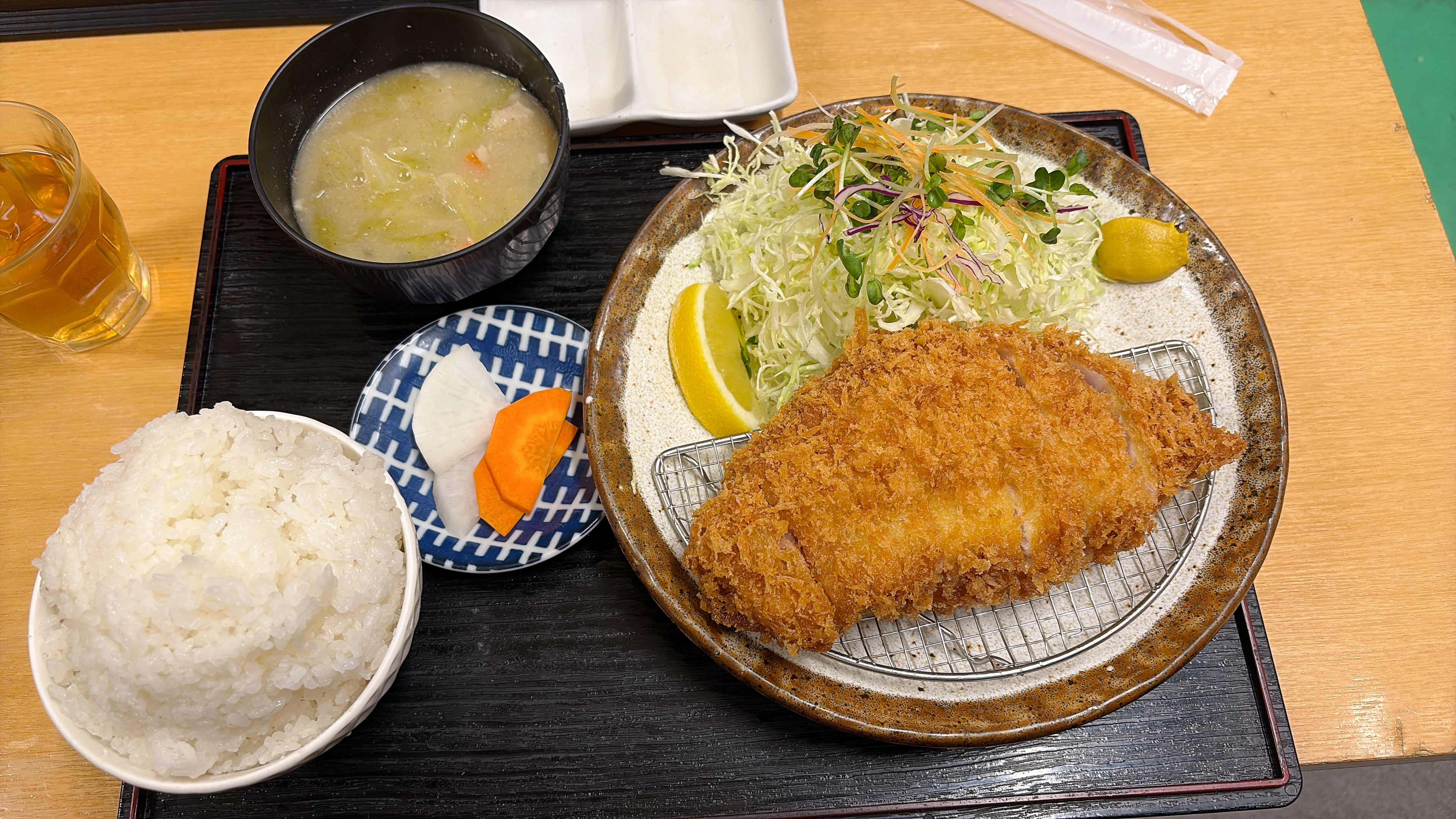 上ロースかつ定食の全体写真。とんかつ、キャベツ、ごはん、味噌汁が写っている